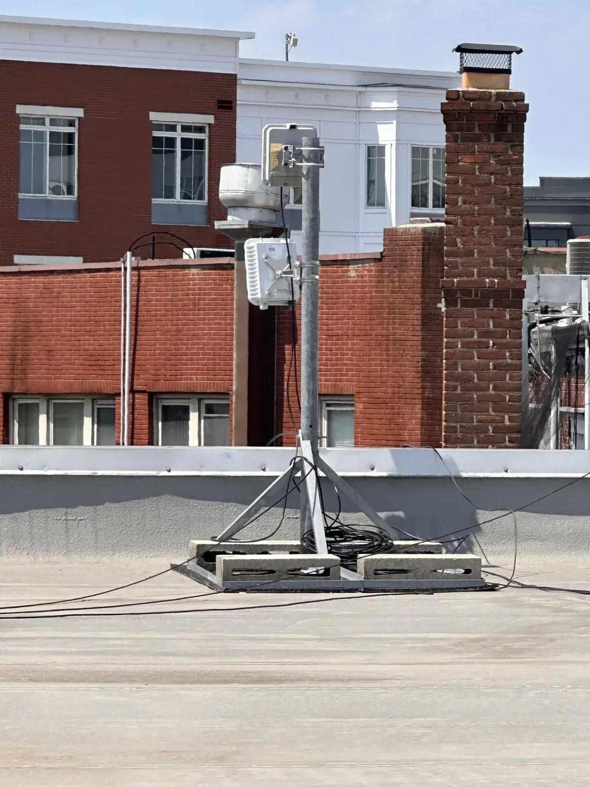 Rooftop wireless mast providing property-wide coverage